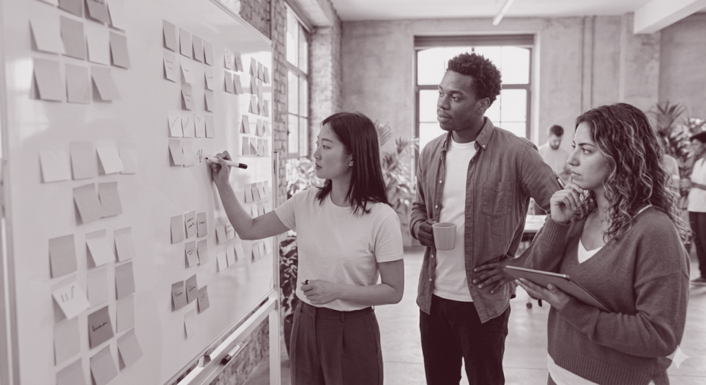 Social Media Strategieentwicklung: drei Leute stehen vor einer Planwand