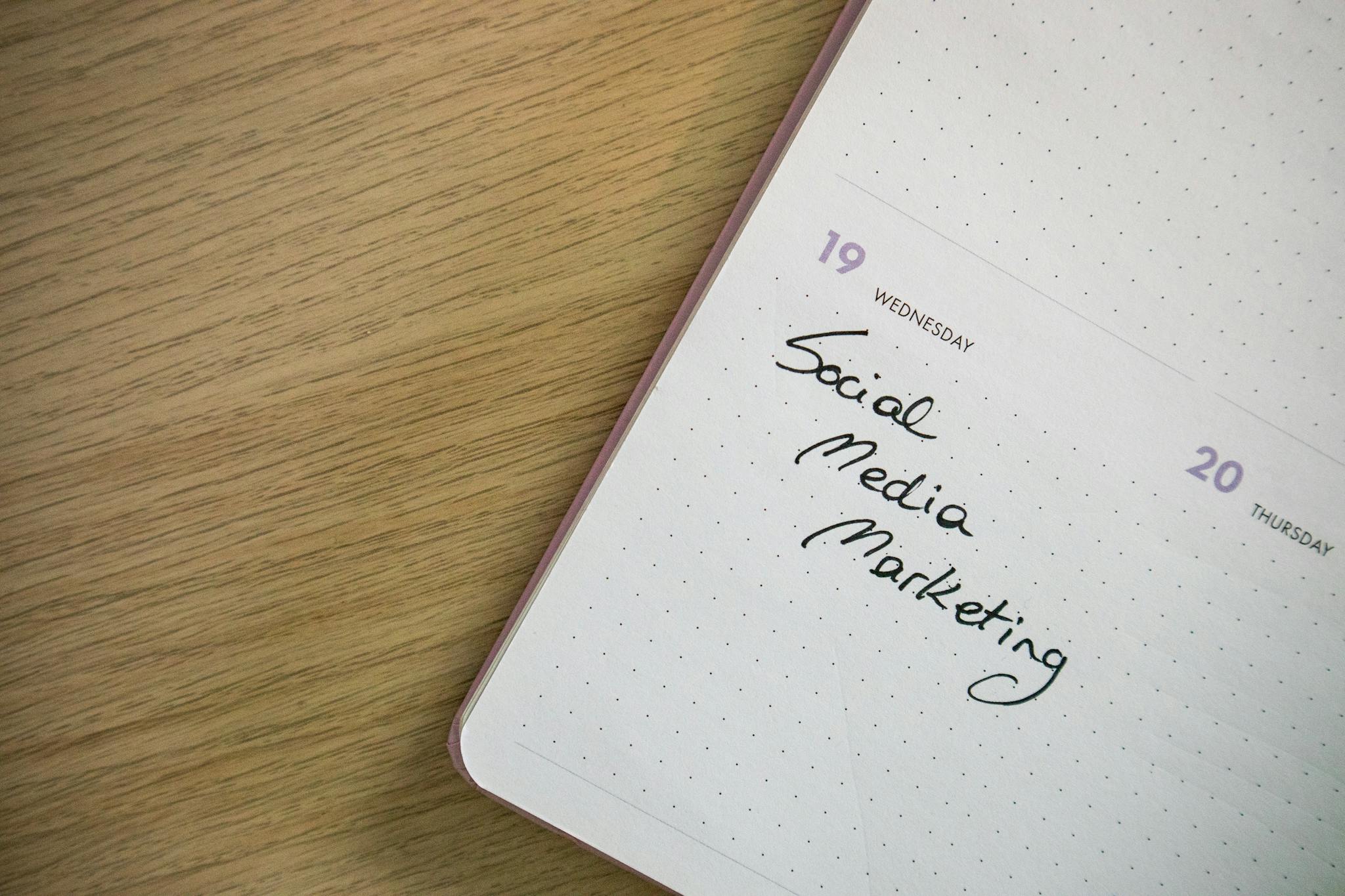 Close-up of a notebook page with 'Social Media Marketing' handwritten on it.